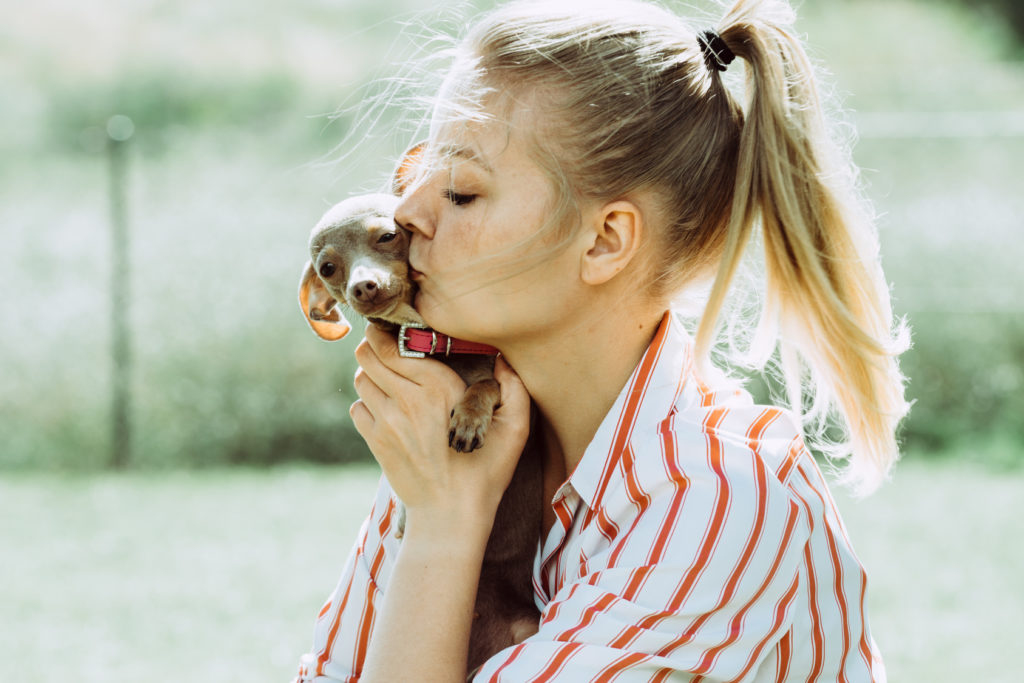 Eine Frau küsst ihren Hundewelpen